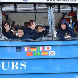 Students waving from a tour bus.