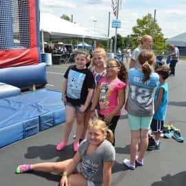 Students standing next to a bouncy house.