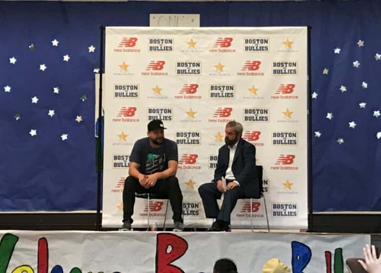 Brian Johnson sitting on a stage with another man