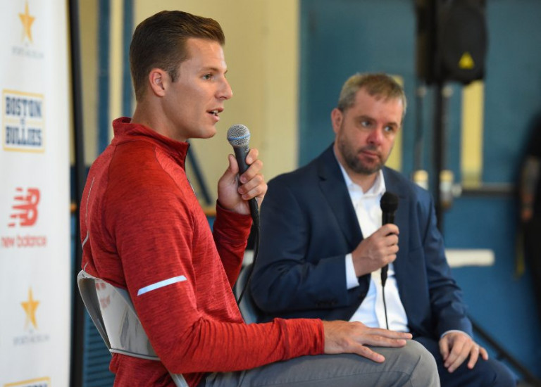 Justin Turri seated and talking into a microphone next to another man